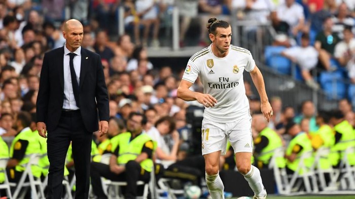 (FILES) In this file photo taken on August 24, 2019 Real Madrids French coach Zinedine Zidane (L) looks at Real Madrids Welsh forward Gareth Bale (R) during the Spanish League football match between Real Madrid and Real Valladolid at the Santiago Bernabeu stadium in Madrid. - Zinedine Zidane faces another crossroads in his handling of Gareth Bale, who appeared to mock Real Madrid after Wales 2-0 victory over Hungary. After sealing qualification for Euro 2020 with a wild win in Cardiff, an ecstatic Bale celebrated next to his teammates behind a flag that read Wales. Golf. Madrid. In that order. (Photo by GABRIEL BOUYS / AFP)