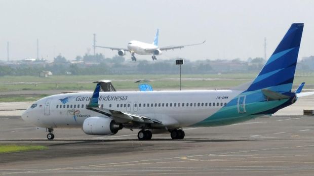 This photograph taken on October 26, 2010, shows an Indonesian Garuda Airline plane landing and another preparing to take off at Soekarno-Hatta airport in Jakarta. Its symbol is Garuda, the winged steed of Vishnu in Hindu mythology, but Garuda Indonesia's fortunes more closely resemble the Phoenix, which rose from the flames to fly again. This, at least, will be the story Indonesia's national carrier takes to potential investors this week as it touts its initial public offering (IPO) around Hong Kong, London and New York.     AFP PHOTO / ROMEO GACAD (Photo by ROMEO GACAD / AFP)