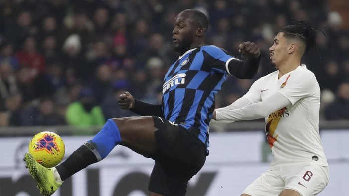 Inter Milans Romelu Lukaku, left, vies for the ball with Romas Chris Smalling during a Serie A soccer match between Inter Milan and Roma, at the San Siro stadium in Milan, Italy, Friday, Dec.6, 2019. (AP Photo/Luca Bruno)