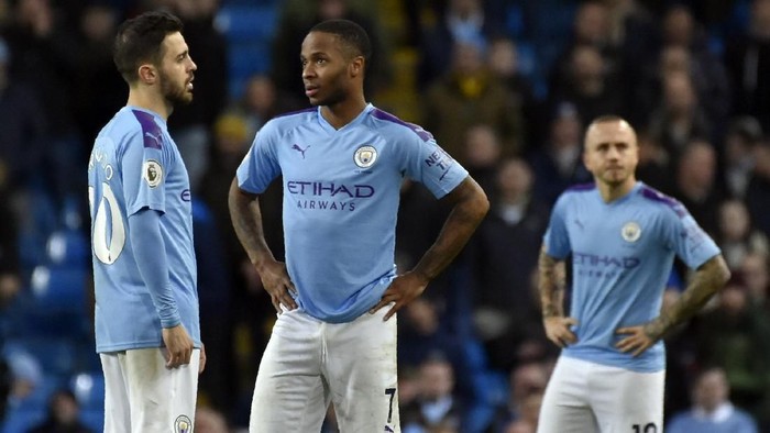 Manchester Citys Bernardo Silva, left, speaks with Manchester Citys Raheem Sterling, center, during the English Premier League soccer match between Manchester City and Manchester United at Etihad stadium in Manchester, England, Saturday, Dec. 7, 2019. (AP Photo/Rui Vieira)