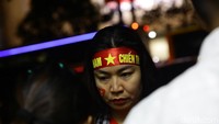 Sebagian suporter Vietnam memakai ikat kepala merah dengan logo bintang.