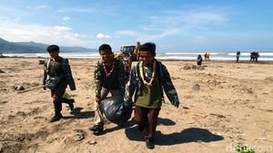 Warga dan TNI Bahu Membahu Bersihkan Sampah di Pantai Loji