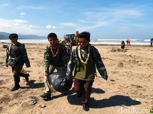 Warga dan TNI Bahu Membahu Bersihkan Sampah di Pantai Loji