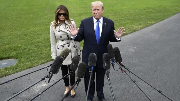 US President Donald Trump talks to the press flanked by First Lady Melania Trump as he prepares to board Marine One for Beltsville, Maryland, in Washington, DC, on October 13, 2017. - Trump earlier on October 13 in a highly-anticipated address refused to certify the 2015 Iranian nuclear deal, and warned the United States may yet walk away from 