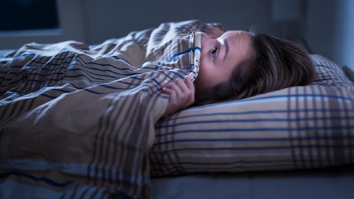 Ilustrasi mimpi buruk Scared woman hiding under blanket. Afraid of the dark. Unable to sleep after nightmare or bad dream. Awake in the middle of the night in bedroom at home. Monster under the bed or in closet.