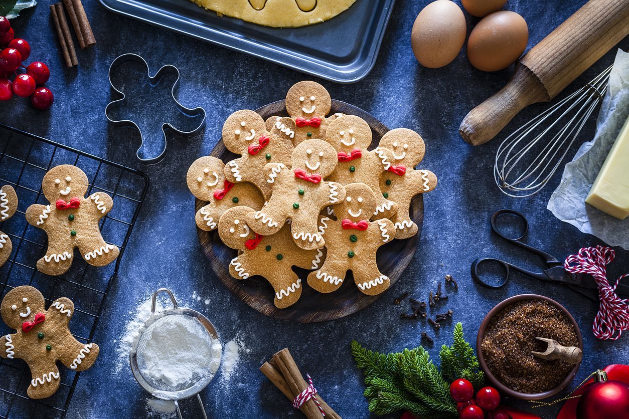 Top view of a bluish tint table with ingredients and utensils for preparing and baking Christmas cookies placed all around the border making a frame and leaving a useful copy space for text and/or logo at the center . Predominant colors are brown and blue. Low key DSRL studio photo taken with Canon EOS 5D Mk II and Canon EF 100mm f/2.8L Macro IS USM