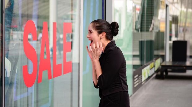 Beautiful caucasian woman excited when see the price tag on sale clothing fashion at the store, discount, shock price