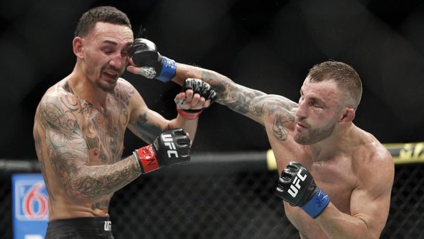 Alexander Volkanovski hits Max Holloway in a mixed martial arts featherweight championship bout at UFC 245, Saturday, Dec. 14, 2019, in Las Vegas. (AP Photo/John Locher)