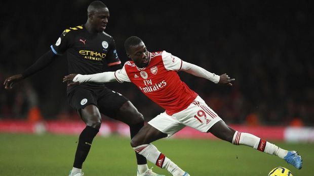 Britain Soccer Premier League Manchester City's Benjamin Mendy, left, fights for the ball with Arsenal's Nicolas Pepe during the English Premier League soccer match between Arsenal and Manchester City, at the Emirates Stadium in London, Sunday, Dec. 15, 2019. (AP Photo/Ian Walton)