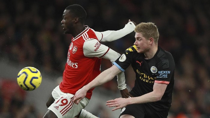 Arsenals Nicolas Pepe, left, fights for the ball with Manchester Citys Kevin De Bruyne during the English Premier League soccer match between Arsenal and Manchester City, at the Emirates Stadium in London, Sunday, Dec. 15, 2019. (AP Photo/Ian Walton)