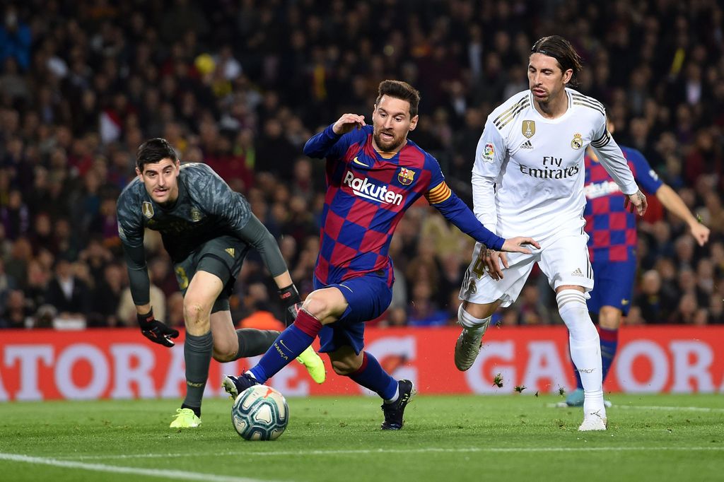 BARCELONA, SPAIN - DECEMBER 18:  Lionel Messi of Barcelona holds off Sergio Ramos of Real Madrid during the Liga match between FC Barcelona and Real Madrid CF at Camp Nou on December 18, 2019 in Barcelona, Spain. (Photo by Alex Caparros/Getty Images)