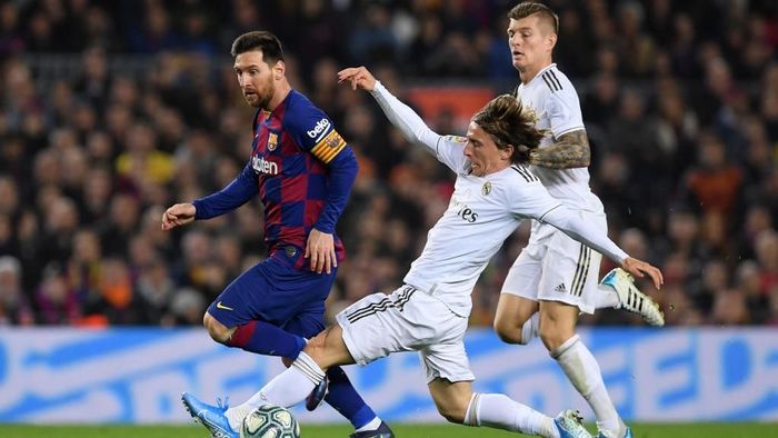 Barcelona vs Real Madrid BARCELONA, SPAIN - DECEMBER 18: Lionel Messi of Barcelona is tackled by Luka Modric of Real Madrid during the Liga match between FC Barcelona and Real Madrid CF at Camp Nou on December 18, 2019 in Barcelona, Spain. (Photo by Alex Caparros/Getty Images)