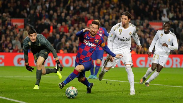 Barcelona's Lionel Messi, center, vies for the ball with Real Madrid's goalkeeper Thibaut Courtois, left, and Real Madrid's Sergio Ramos, second right, during a Spanish La Liga soccer match between Barcelona and Real Madrid at Camp Nou stadium in Barcelona, Spain, Wednesday, Dec. 18, 2019. Thousands of Catalan separatists are planning to protest around and inside Barcelona's Camp Nou Stadium during Wednesday's