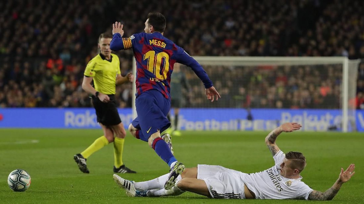 Toni Kroos menahan laju Lionel Messi dalam pertandingan Barcelona vs Real Madrid (Foto: AP Photo/Emilio Morenatti)