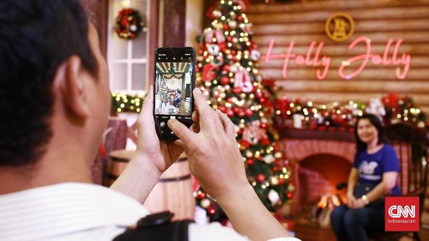 Pengunjung berfoto di spot atribut perayaan Natal yang telah disediakan oleh pihak Mall Grand Indonesia. Jakarta. Kamis (19/12/2019) Tahun ini pihak mall memasang atribut Natal dengan konsep suasana negara Jerman. CNN Indonesia/Andry Novelino