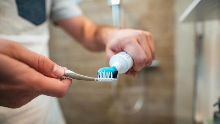 ilustrasi pasta gigi Dental health care concept. Close-up of man squeezes toothpaste on the toothbrush.