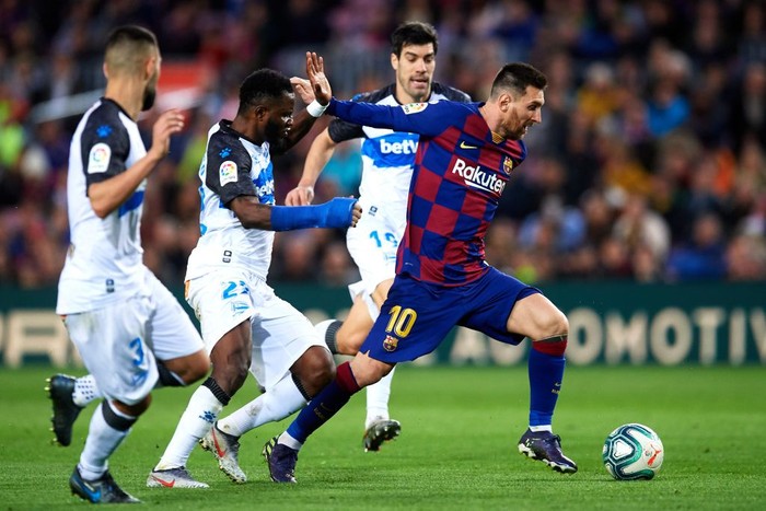 BARCELONA, SPAIN - DECEMBER 21: Lionel Messi of FC Barcelona eludes the pressure from Ruben Duarte, Wakaso Mubarak and Manu Garcia of Deportivo Alaves to score his teams third goal during the La Liga match between FC Barcelona and Deportivo Alaves at Camp Nou on December 21, 2019 in Barcelona, Spain. (Photo by Alex Caparros/Getty Images)
