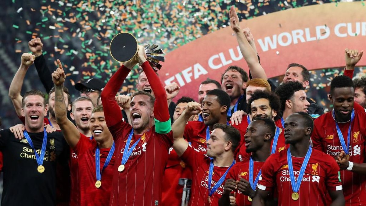 Henderson (mengangkat trofi) senang dengan status baru Liverpool sebagai juara dunia. Foto: Francois Nel/Getty Images