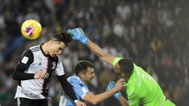 Lazio's goalkeeper Thomas Strakosha, right, beats the ball away from Juventus Cristiano Ronaldo, left, during their Super Cup match at King Saud University Stadium, in Riyadh, Saudi Arabia, Sunday, Dec. 22, 2019. (AP Photo/Nasser Alharbi)