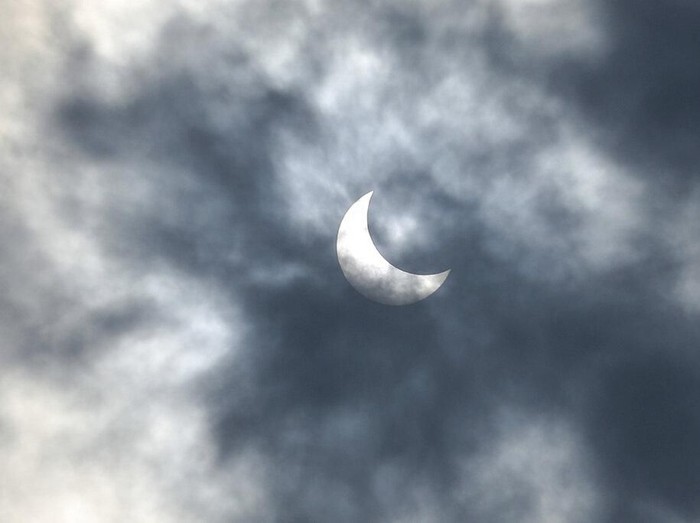 People look up at the sun with protective glasses to watch a solar eclipse from Jakarta, Indonesia, Thursday, Dec. 26, 2019. (AP Photo/Tatan Syuflana)