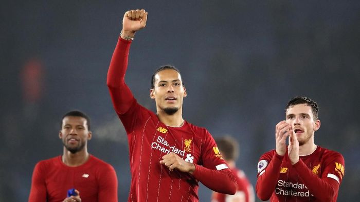 Virgil van Dijk membantu petugas pemotong rumput usai laga Leicester City vs Liverpool (Foto: Photo by Alex Pantling/Getty Images)