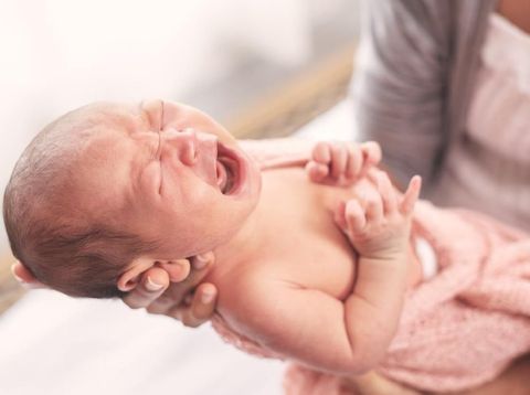 Selected focus on little cute baby crying on her mother hand.