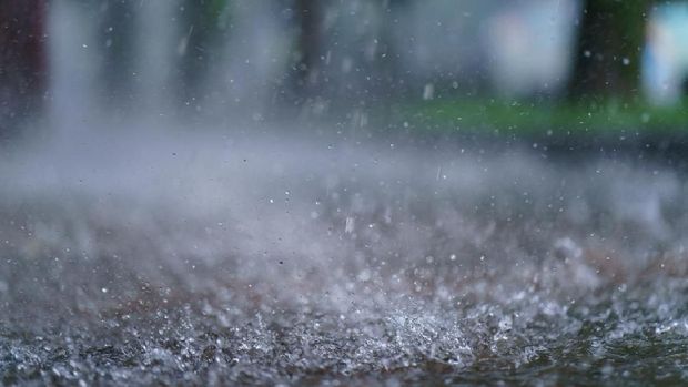 Texture of strong, fresh and powerful water drops and sprays. Puddle with ripple on the road. Tropical rains in Russia, Moscow as a result of global warming
