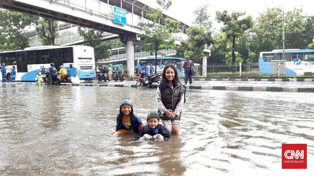 Dua putra Ariyadi dan keponakannya bersama-sama bermain di 'waterpark'.