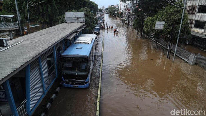 Bus TransJakarta tetap beroperasi walaupun banjir. Salah satunya di kawasan Pasar Baru. Yuk, intip foto-fotonya.