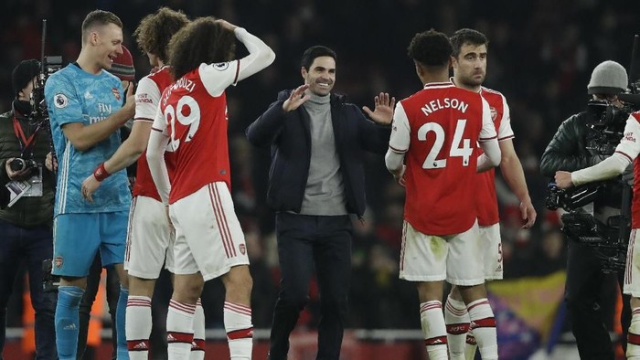 Arsenal manager Mikel Arteta, center, celebrates with his players at the end of the English Premier League soccer match between Arsenal and Manchester United at the Emirates Stadium in London, Wednesday, Jan. 1, 2020. Arsenal defeated Manchester 2-0. (AP Photo/Matt Dunham)