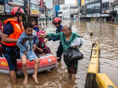 Petugas Damkar Evakuasi Korban Banjir di Kampung Pulo