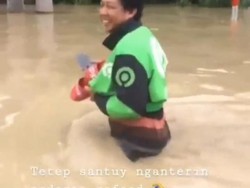 Di Tengah Banjir, Ojol Ini Tetap Semangat Antar Pesanan Makanan