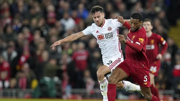 Liverpool's Georginio Wijnaldum, right, duels for the ball with Sheffield United's George Baldock during the English Premier League soccer match between Liverpool and Sheffield United at Anfield Stadium, Liverpool, England, Thursday, Jan. 2, 2020. (AP Photo/Jon Super)