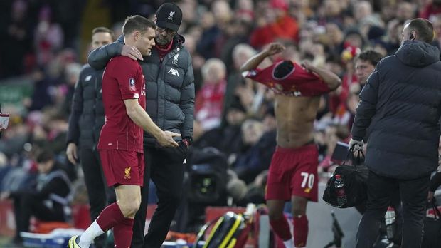 Liverpool's James Milner leaves the field as he embraced by his coach Jurgen Klopp during the English FA Cup third round soccer match between Liverpool and Everton at Anfield stadium in Liverpool, England, Sunday, Jan. 5, 2020. (AP Photo/Jon Super)