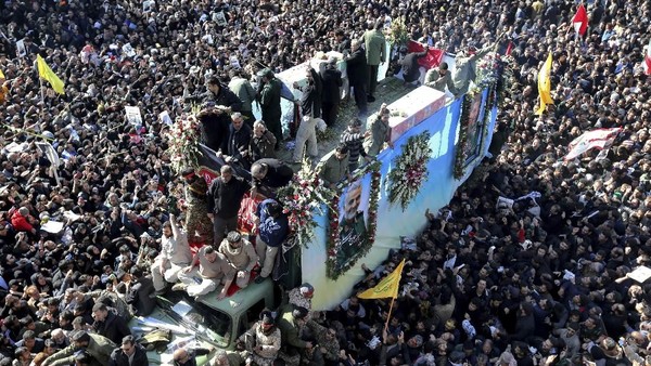 Foto: Peti yang berisi jenazah Qasem Soleimani dibawa dengan truk yang dikerumuni para pelayat di Kerman (AP Photo) Foto: Peti yang berisi jenazah Qasem Soleimani dibawa dengan truk yang dikerumuni para pelayat di Kerman (AP Photo)