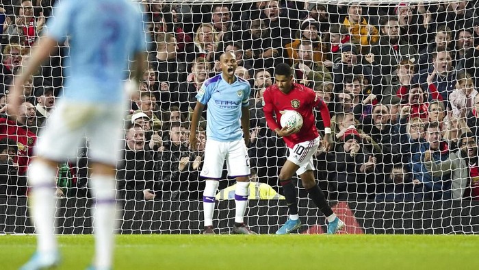 Manchester Uniteds Marcus Rashford, right collects the ball after scoring is sides first goal during the English League Cup semifinal first leg soccer match between Manchester United and Manchester City and at Old Trafford, Manchester, England, Tuesday, Jan. 7, 2020. (AP Photo/Jon Super)