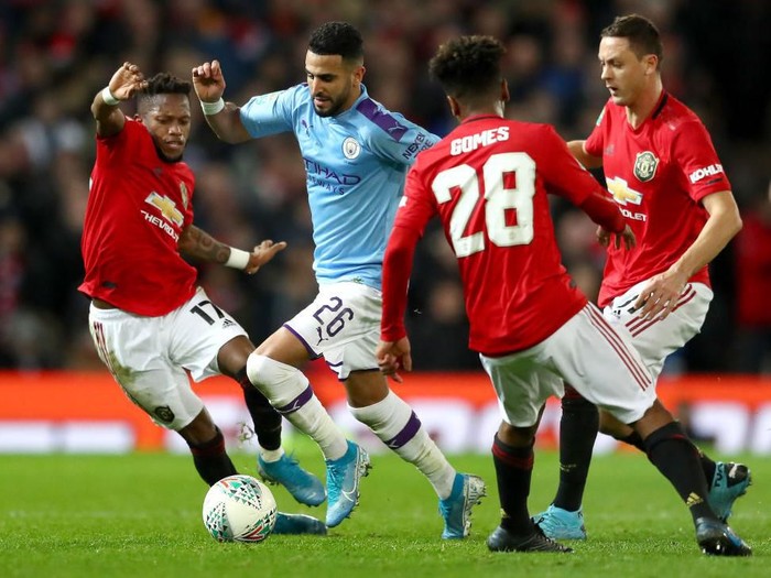 MANCHESTER, ENGLAND - JANUARY 07: Riyad Mahrez of Manchester City is challenged by Fred, Nemanja Matic and Angel Gomes of Manchester United during the Carabao Cup Semi Final match between Manchester United and Manchester City at Old Trafford on January 07, 2020 in Manchester, England. (Photo by Michael Steele/Getty Images)
