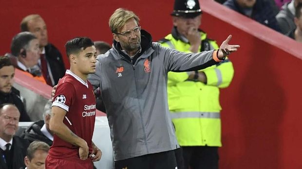 Liverpool's German manager Jurgen Klopp (C) speaks to Liverpool's Brazilian midfielder Philippe Coutinho as he prepares to play during the UEFA Champions League Group E football match between Liverpool and Sevilla at Anfield in Liverpool, north-west England on September 13, 2017. (Photo by Paul ELLIS / AFP)