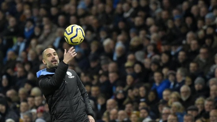 Manchester Citys head coach Pep Guardiola passes the ball during the English Premier League soccer match between Manchester City and Everton at Etihad stadium in Manchester, England, Wednesday, Jan. 1, 2020. (AP Photo/Rui Vieira)