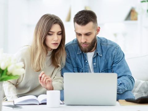 Confident couple trying to manage domestic finances, calculating and making notes