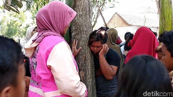 Seorang warga menempelkan telinganya untuk mendengarkan suara dari pohon (Foto: Yakub Mulyono)