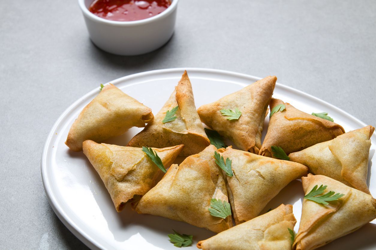 Plate vegetarian samosas on gray background