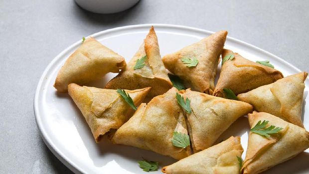 Plate vegetarian samosas on gray background