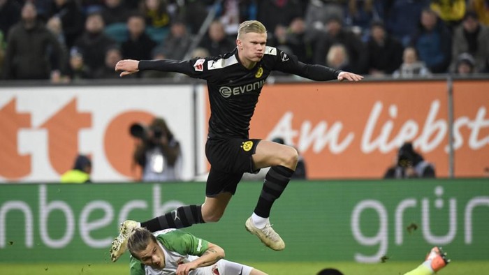 Dortmund's Norwegian forward Erling Braut Haaland jumps over Augsburg's Czech goalkeeper Tomas Koubek and Croatian defender Tin Jedvaj after he scored during the German first division Bundesliga football match Augsburg v Borussia Dortmund in Augsburg, on January 18, 2020. (Photo by THOMAS KIENZLE / AFP) / DFL REGULATIONS PROHIBIT ANY USE OF PHOTOGRAPHS AS IMAGE SEQUENCES AND/OR QUASI-VIDEO
