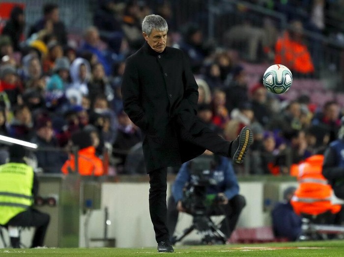 Barcelonas head coach Quique Setien kicks the ball back to the pitch during a Spanish La Liga soccer match between Barcelona and Granada at Camp Nou stadium in Barcelona, Spain, Sunday, Jan. 19, 2020. (AP Photo/Joan Monfort)