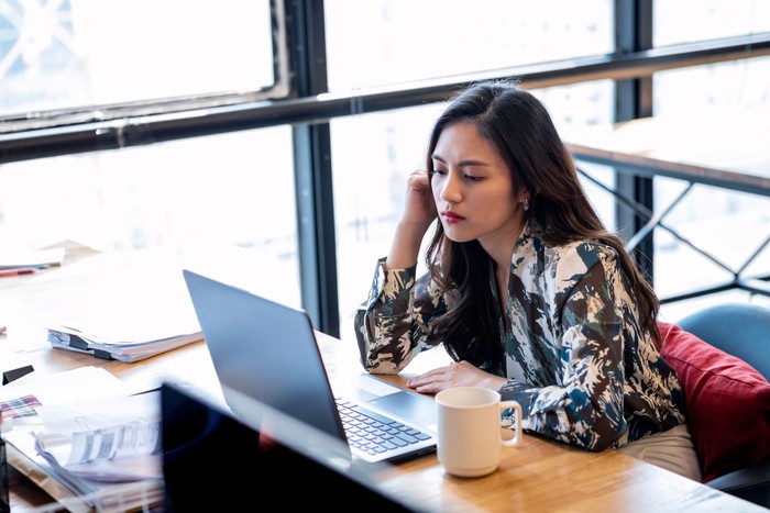 Sitting At A Desk And Working With Her Laptop Computer In The Office