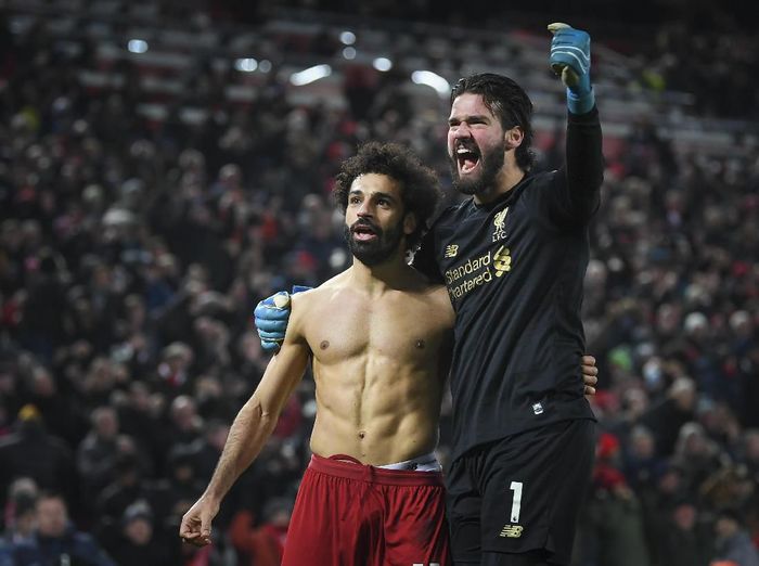 Alisson Becker merayakan gol kedua Liverpool ke gawang Manchester United bersama Mohamed Salah (Michael Regan/Getty Images)