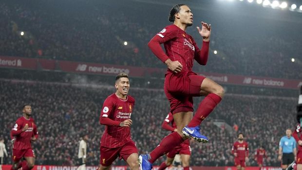 Liverpool's Virgil van Dijk jumps to celebrate scoring his side's first goal during the English Premier League soccer match between Liverpool and Manchester United at Anfield Stadium in Liverpool, Sunday, Jan. 19, 2020.(AP Photo/Jon Super)