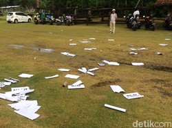 Poster-poster protes suporter tampak berserakan di tengah lapangan.