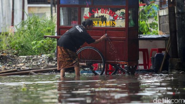 Di Tengah Banjir, Pedagang Ini Tetap Jualan demi Cuan